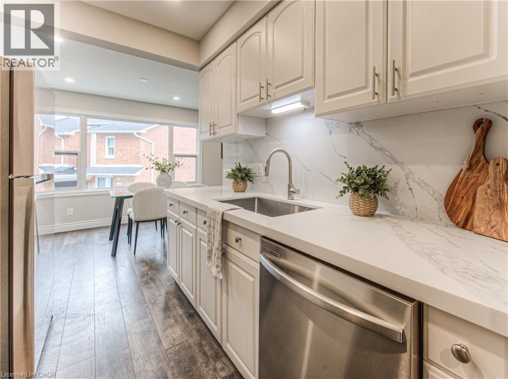 Kitchen with dishwasher, a sink, freestanding refrigerator, dark wood-style flooring, and decorative backsplash - 425 Keats Way Unit# 4, Waterloo, ON - Indoor Photo Showing Kitchen With Upgraded Kitchen