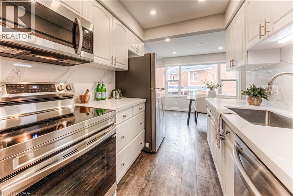 Kitchen with appliances with stainless steel finishes, a sink, white cabinets, dark wood-style flooring, and recessed lighting - 425 Keats Way Unit# 4, Waterloo, ON - Indoor Photo Showing Kitchen With Upgraded Kitchen