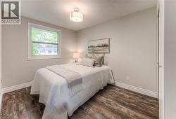 Bedroom with wood finished floors and baseboards -
