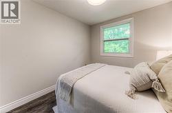 Bedroom featuring dark wood finished floors and baseboards -