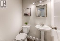 Half bathroom featuring toilet and baseboards -