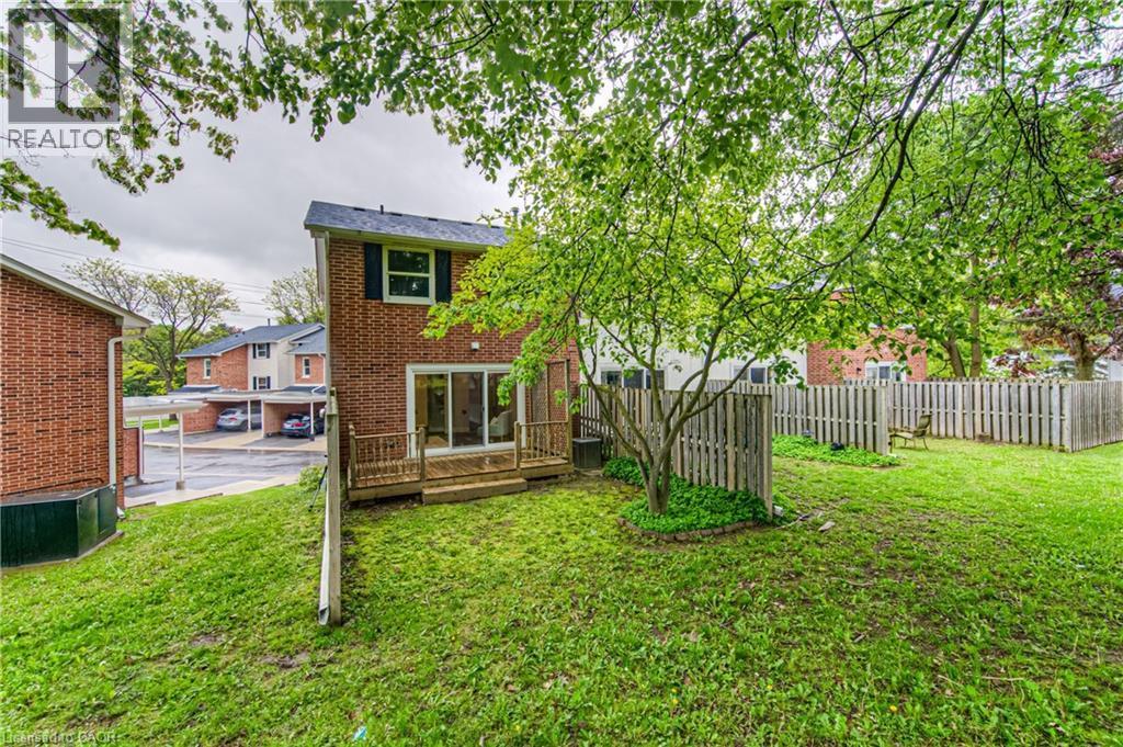 Back of property featuring brick siding, a wooden deck, and central air condition unit - 425 Keats Way Unit# 4, Waterloo, ON - Outdoor
