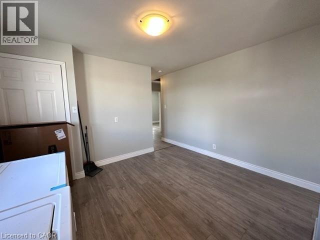 Unfurnished bedroom featuring dark wood finished floors and washer / clothes dryer - 121 Roberts Crescent Unit# Upper, Kitchener, ON - Indoor Photo Showing Other Room