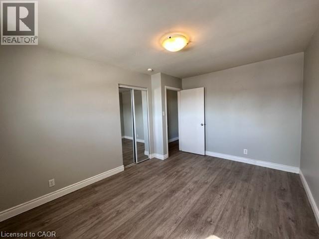 Unfurnished bedroom featuring dark wood-style flooring and a closet - 121 Roberts Crescent Unit# Upper, Kitchener, ON - Indoor Photo Showing Other Room