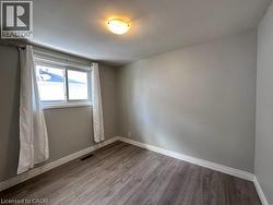 Spare room featuring baseboards and wood finished floors -