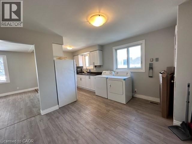 Laundry room with light wood-type flooring and independent washer and dryer - 121 Roberts Crescent Unit# Upper, Kitchener, ON - Indoor Photo Showing Laundry Room