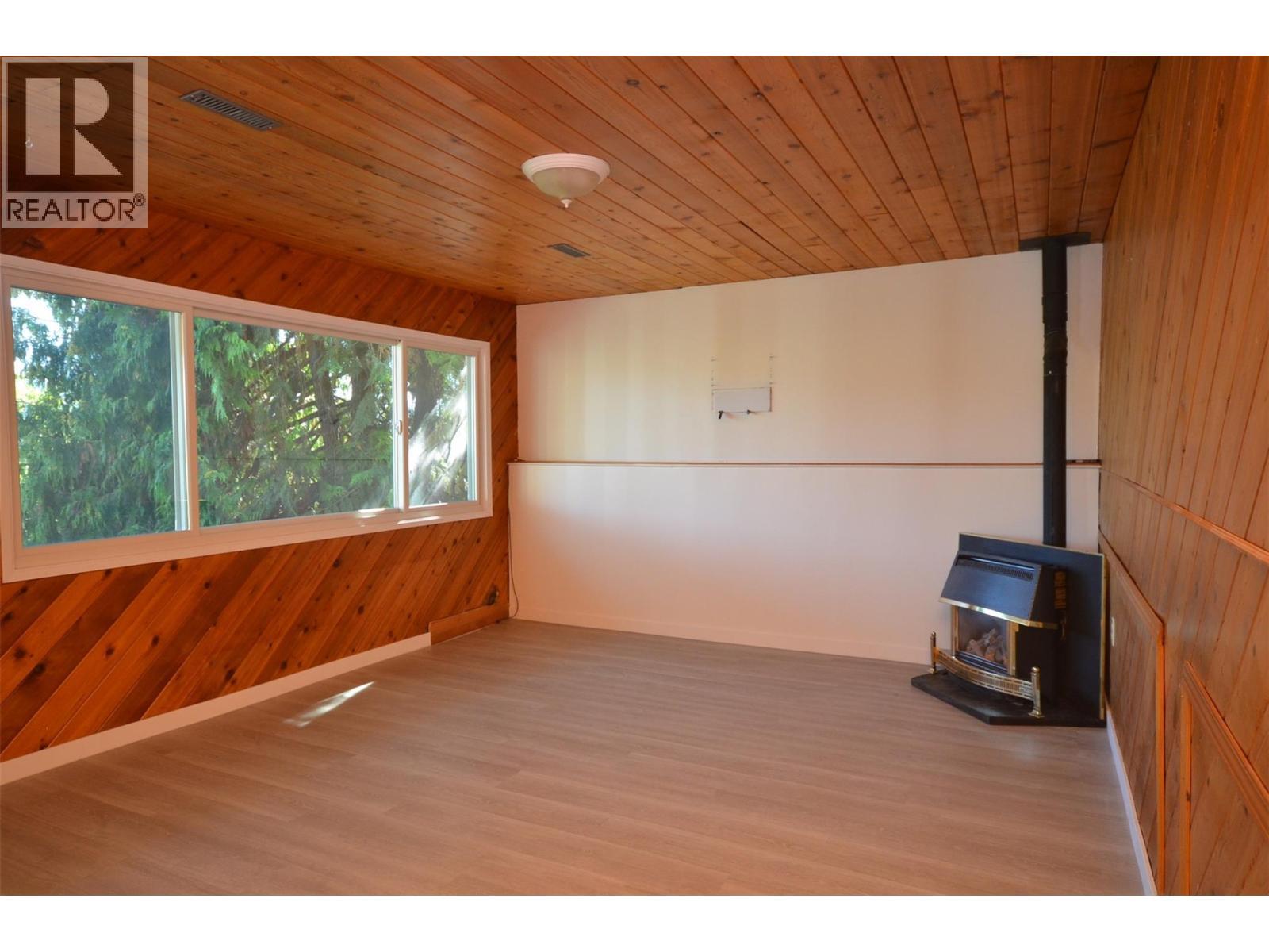 Gas fireplace, bright windows - 6609 Southwind Road, Vernon, BC - Indoor Photo Showing Other Room