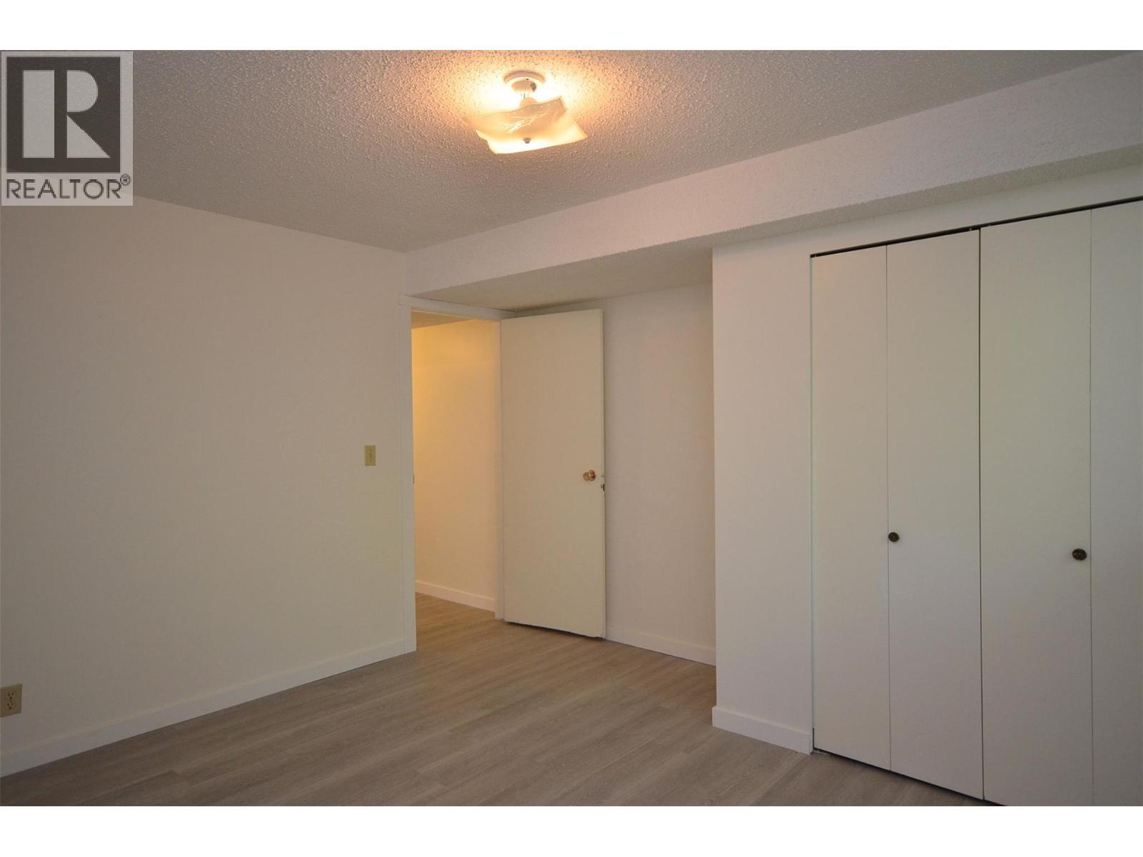 Third bedroom - double closets - 6609 Southwind Road, Vernon, BC - Indoor Photo Showing Other Room