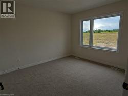 Spare room featuring carpet and baseboards -