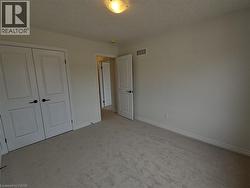 Unfurnished bedroom featuring light carpet and a closet -