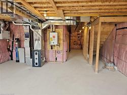 Unfinished basement with tankless water heater, heating unit, and a water softener -