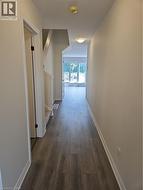 Corridor with baseboards and dark wood-type flooring -