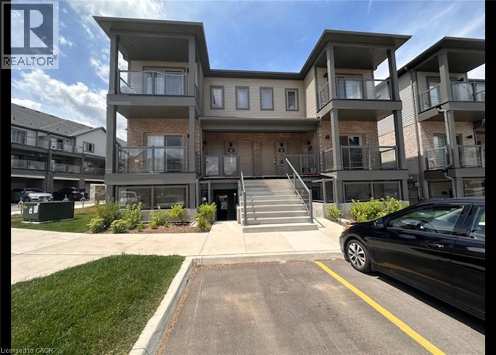 View of property featuring uncovered parking and stairway - 205 West Oak Trail Unit# 66, Kitchener, ON - Outdoor With Balcony With Facade