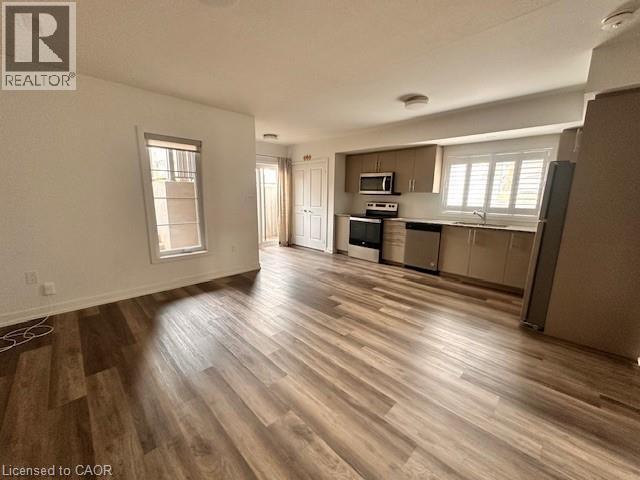 Kitchen featuring stainless steel appliances, light countertops, open floor plan, and healthy amount of natural light - 205 West Oak Trail Unit# 66, Kitchener, ON - Indoor Photo Showing Kitchen