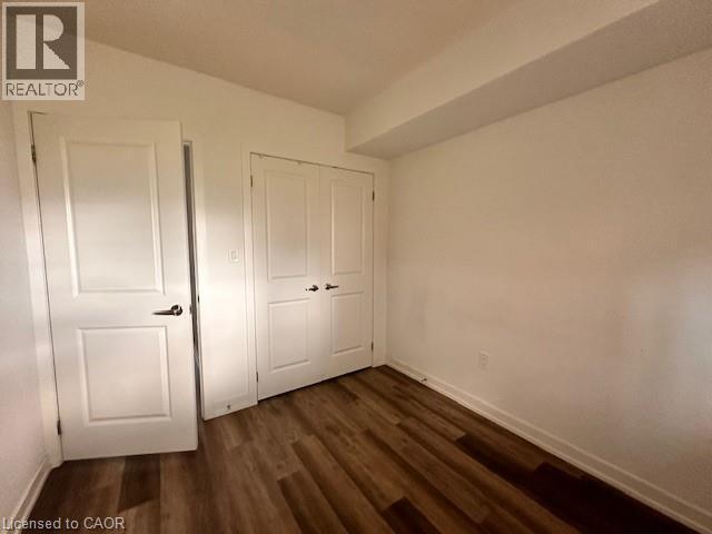 Unfurnished bedroom featuring dark wood finished floors and a closet - 205 West Oak Trail Unit# 66, Kitchener, ON - Indoor Photo Showing Other Room