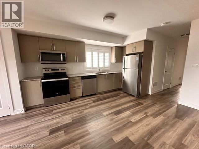 Kitchen with stainless steel appliances, gray cabinetry, light countertops, and dark wood finished floors - 205 West Oak Trail Unit# 66, Kitchener, ON - Indoor Photo Showing Kitchen With Stainless Steel Kitchen