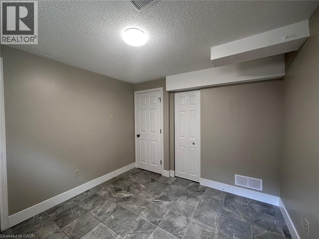 Basement featuring baseboards and a textured ceiling - 17 St Leger Street, Kitchener, ON - Indoor Photo Showing Other Room
