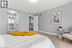 Bedroom featuring light colored carpet, a textured ceiling, and ensuite bath -