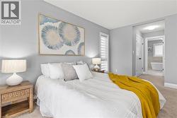 Bedroom with light carpet and ensuite bath -