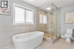 Full bath featuring a freestanding bath, a shower stall, tile patterned floors, a textured ceiling, and tile walls -