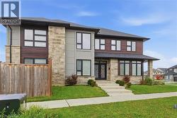 View of front of home featuring stone siding, a shingled roof, and french doors -