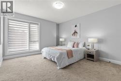 Carpeted bedroom with a textured ceiling and baseboards -