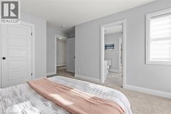 Bedroom with light carpet and ensuite bathroom -