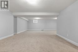 Finished basement with light carpet and a textured ceiling -
