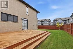 Wooden deck with a fenced backyard and a residential view -