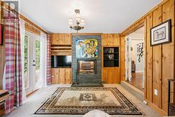 Den showing double sided wood burning fireplace. -