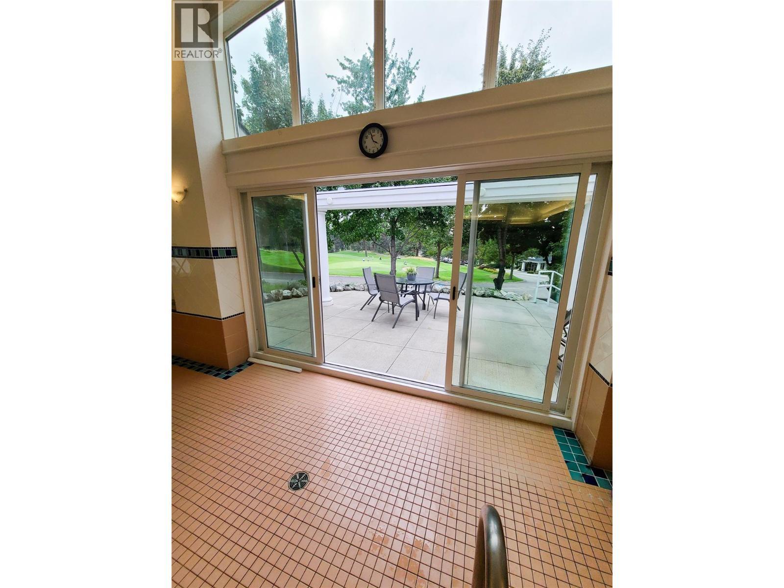 view of the 18th green from the pool. Swim and then relax and read while watching golfers - 3897 Gallaghers Grange, Kelowna, BC - With Exterior