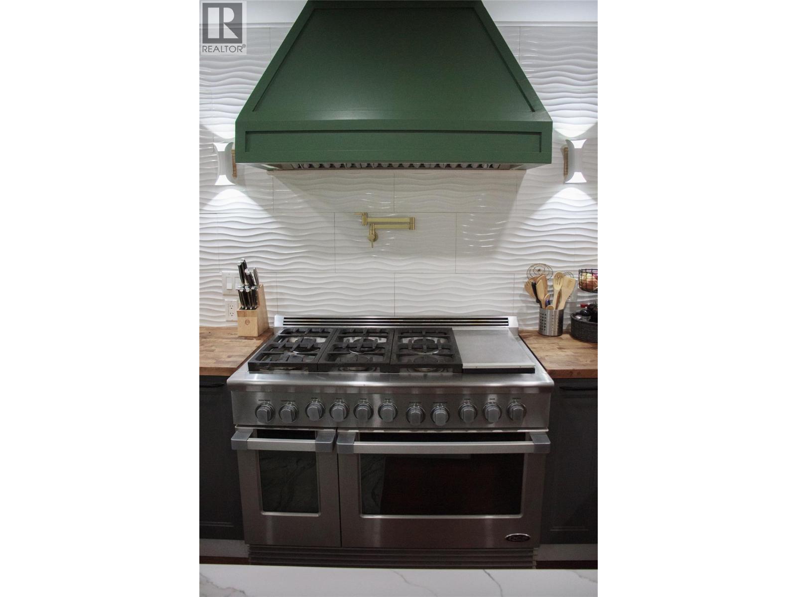 48 inch gas stove with flat top grill, pot filler and large exhaust vent/light - 3897 Gallaghers Grange, Kelowna, BC - Indoor Photo Showing Other Room