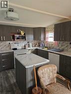 Kitchen featuring dark brown cabinets, modern cabinets, dishwasher, and backsplash -
