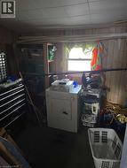 Laundry area featuring clothes dryer, wood walls, and heating unit -