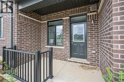 Doorway to property with covered porch and brick siding -