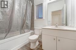 Bathroom featuring shower / tub combo, vanity, and light wood-type flooring -