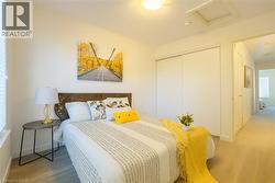 Bedroom featuring attic access, a closet, and wood finished floors -
