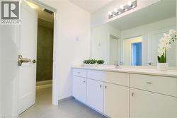 Bathroom featuring a shower stall, light tile patterned floors, and vanity -