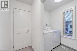 Washroom with light tile patterned floors and washer and clothes dryer -
