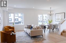 Living room featuring light wood-style flooring, recessed lighting, a chandelier, and stairway -