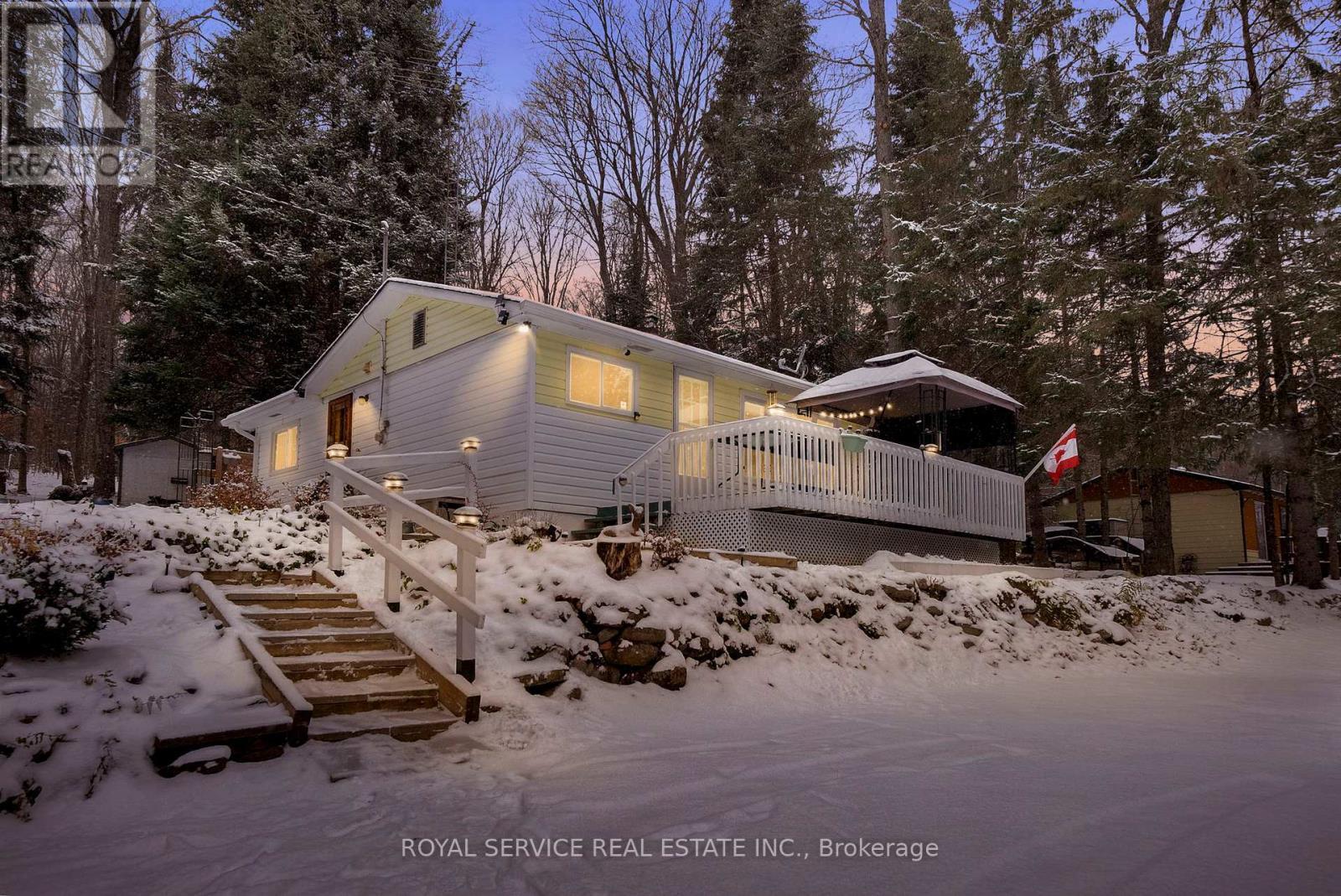 View of Home at Twilight - 1039 Grace River Road, Highlands East (Monmouth), ON - Outdoor With Body Of Water