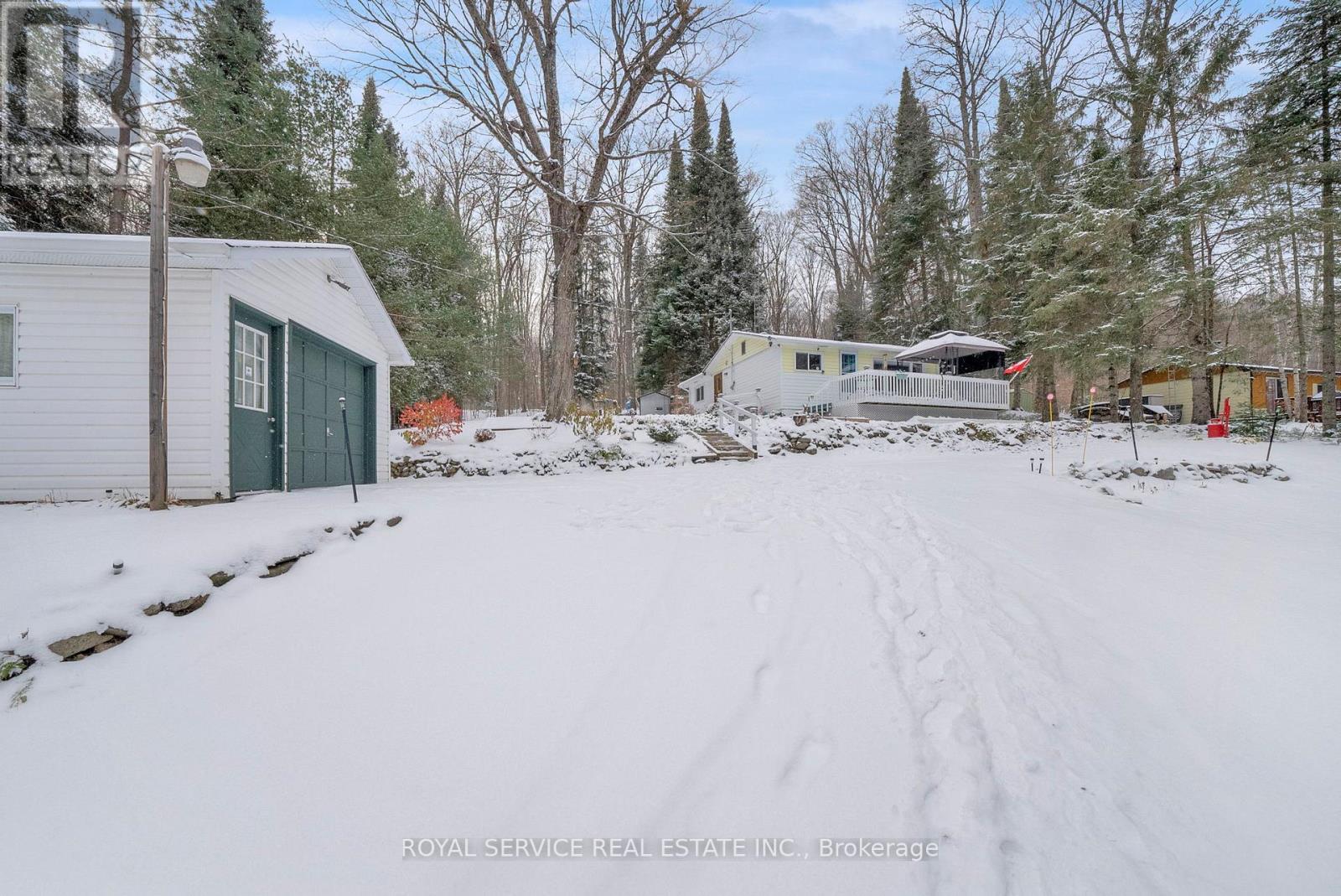 Driveway View of Garage and House - 1039 Grace River Road, Highlands East (Monmouth), ON - Outdoor