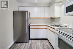 Spacious European-style kitchen with ceiling fan, double sink, ample cabinetry, fridge, stove, and microwave included -