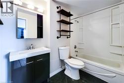 4 piece bathroom with vanity, bathtub, shower combination and wall shelves -