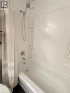 4 piece bathroom with vanity, bathtub, shower combination and wall shelves -