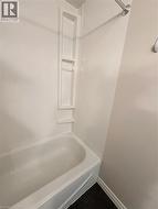 4 piece bathroom with vanity, bathtub, shower combination and wall shelves -