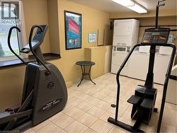 Building phone app laundry located on the main floor. Workout area featuring stacked washer and dryer. -