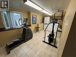 Building phone app laundry located on the main floor. Workout area featuring stacked washer and dryer. -