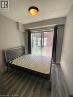 Bedroom with wood finished floors and a textured ceiling -