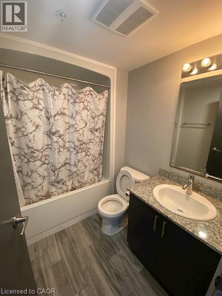 Full bath with shower / tub combo, vanity, and dark wood-type flooring - 275 Larch Street Unit# F313, Waterloo, ON - Indoor Photo Showing Bathroom